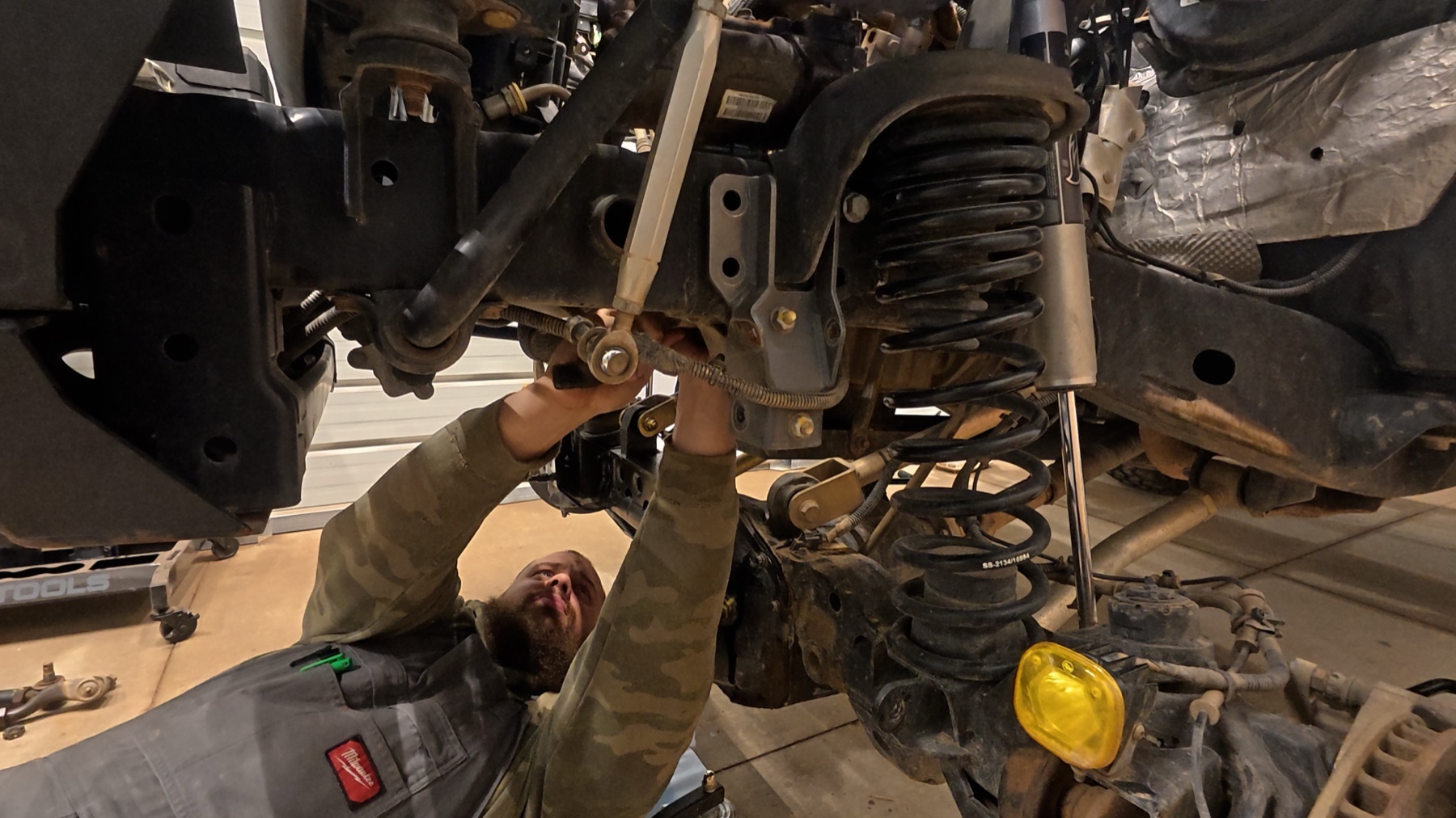 Rob working underneath a lifted Jeep during a suspension build